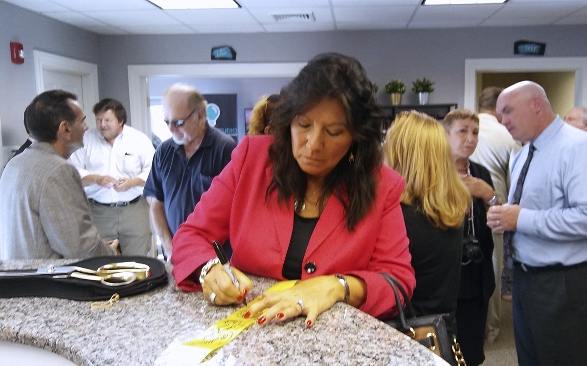 Senator Sue Serino signing the ribbon at the open house for Content Studio at Martinelli Custom Publishing.